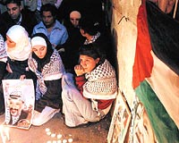 YEN ALAMA DUVARI Ramallah'ta Filistinliler liderlerine kar son grevlerini yerine getirmek iin, ellerinde posterler, mumlar ve Filistin bayraklaryla Mukata'ya kouyor. Kadnlar liderleri iin at yakyor.